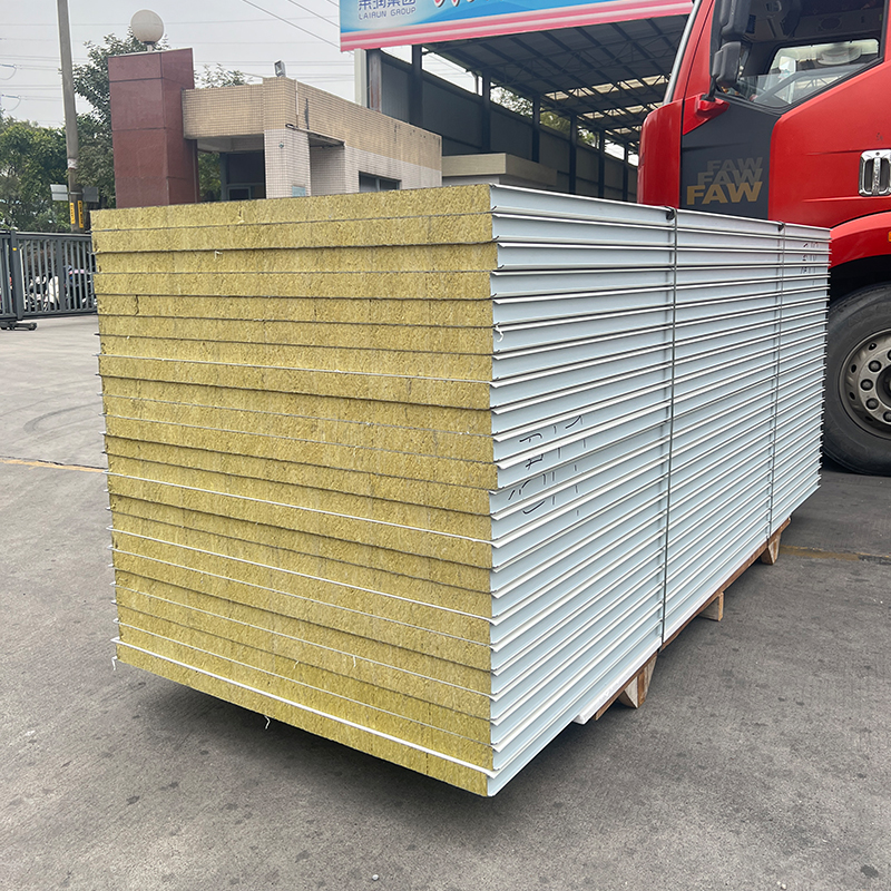 Rockwool sandwich panels stacked on a pallet beside a truck: a panel loading and stacking picture, not a factory or fleet picture.